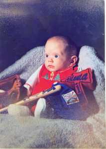 Trip Block as a baby, sitting upright, posing with baseball-themed props